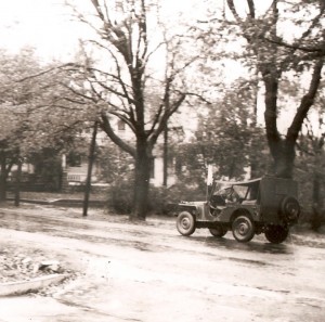A 5th Division jeep rolls down an Albion side street.