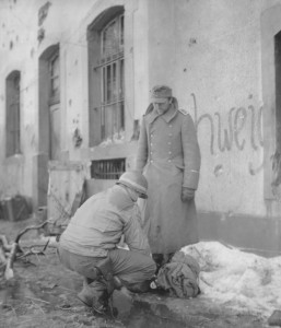 Sergeant Adolf Yost, of Stiles, Pennsylvania, searches a recently captured German soldier, the 25,000th captured by the 90th Infantry Division in World War II - Binsfield, Luxembourg - January 31, 1945. (U.S. Army Signal Corps Photo, Courtesy National Archives)