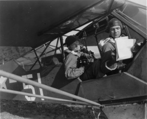90th Infantry Division Artillery Observation Pilot, Lt. Donald H. Olsen (Sturgeon Bay, WI), discusses flight route with Signal Corps cameraman, Tech. Sgt. Harold A. Stillings (Milton, NH), tasked with recording combat troops crossing the Rhine River (Schmidtheim, Germany - March 1945). U.S. Army Signal Corps Photo, Courtesy National Archives