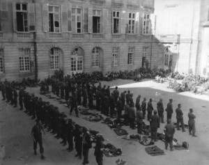 German POWs, waiting for processing, line up in a church yard at Sees, France - August 1944. (U.S. Army Signal Corps Photo, Courtesy National Archives)
